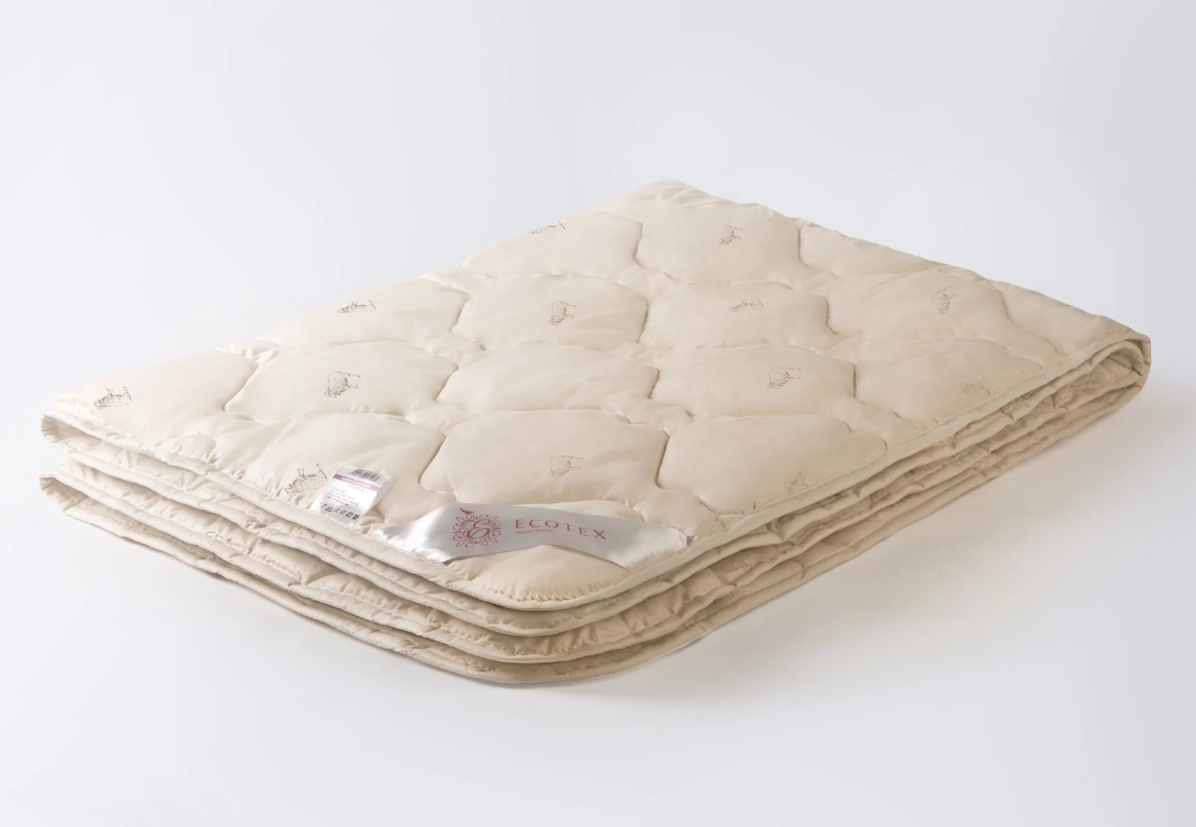 Close-up photography of a soft duvet featuring the Ecotex brand label attached to the edge. The shot highlights the fabric texture and stitching quality
