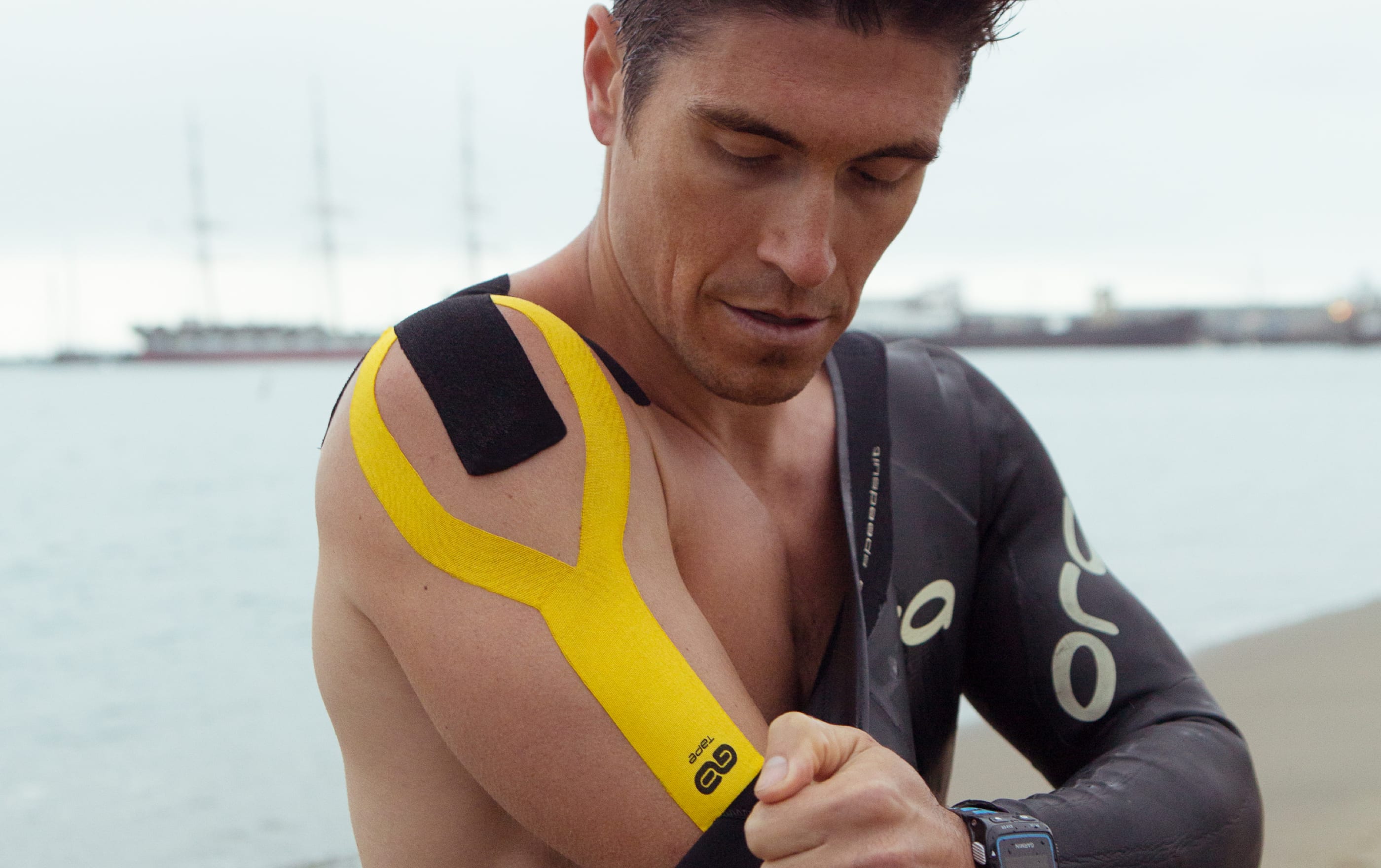 Athlete applying yellow kinesiology gotape