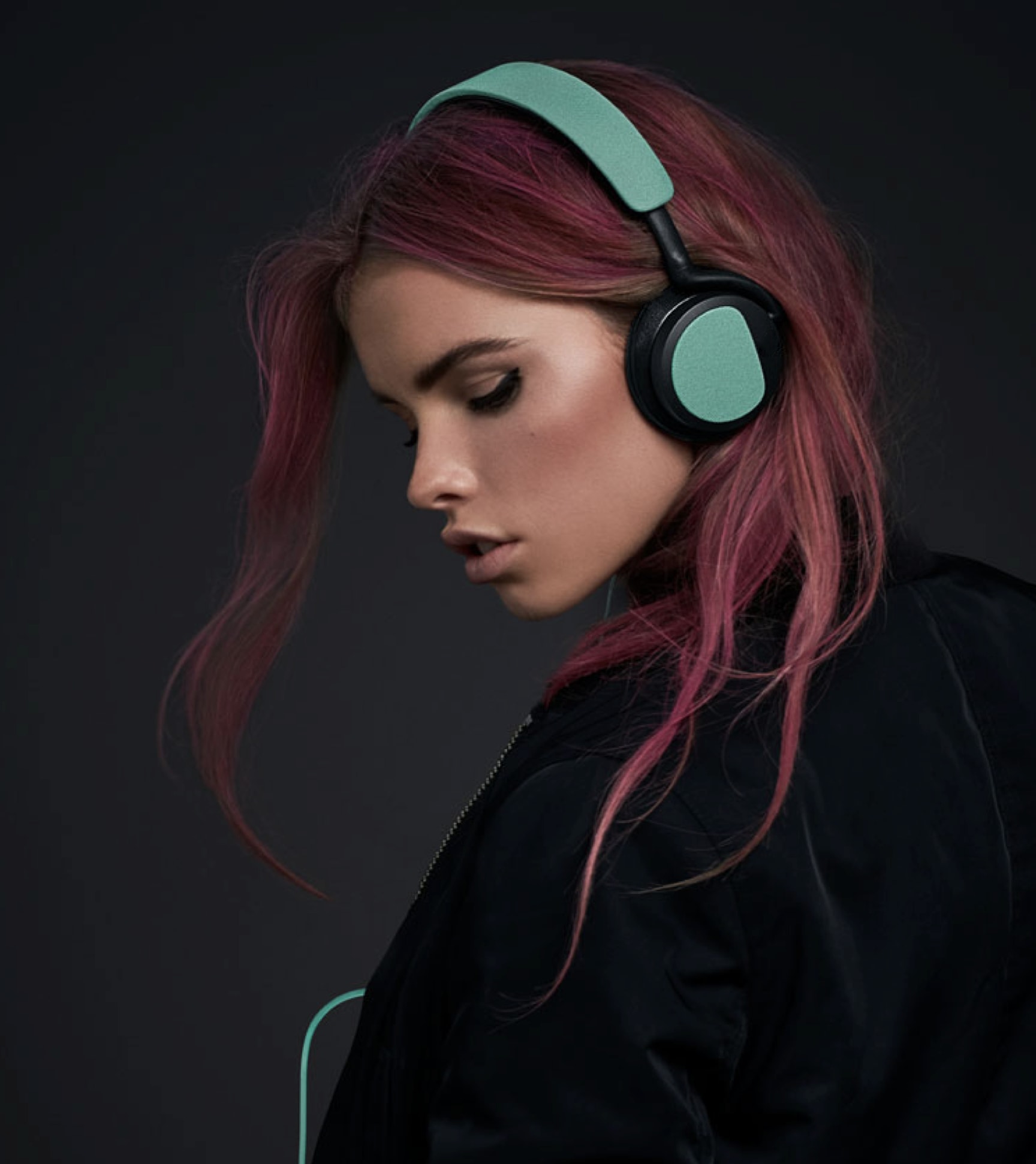 Person with pink hair and headphones